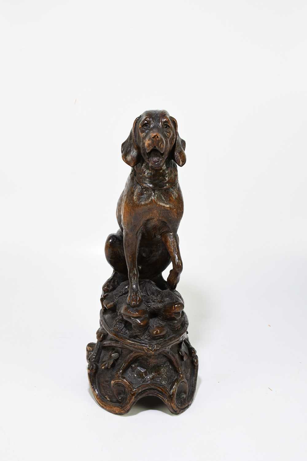 A late 19th century Black Forest large carved soft wood model of a seated dog, on naturalistic - Image 2 of 6