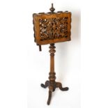 A Victorian walnut duet music stand, with serpentine and pierced music rests, on turned column and