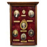 M. EATON; a mahogany framed glazed cabinet housing seven hand painted portrait miniatures on ivory