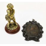 A late 19th century polished bronze figure of a boy holding a grotesque mask, on marble plinth base,