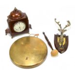 An Edwardian oak and brass dinner gong, the shield shaped back plate modelled with a stag's head,