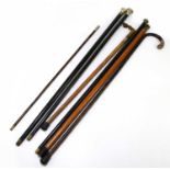 A collection of six walking canes to include a hallmarked silver mounted example with ebonised