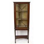 An Edwardian inlaid mahogany display cabinet, the single glazed door enclosing two fixed shelves, on