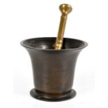 An 18th century bronze mortar, with flared rim on a circular foot, height 11cm, with an associated