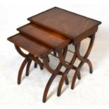 A reproduction mahogany nest of three tables, on curved legs, height 58cm, width 56cm, depth 39cm.