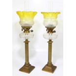 A near pair of 19th century oil lamps with yellow and clear glass shades and etched with floral