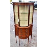 An Edwardian mahogany serpentine display cabinet, with glazed door, above four drawers, height