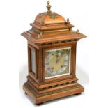 A late 19th century German walnut mantel clock with gilt metal urn finial and applied detail, the