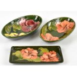 MOORCROFT; two oval bowls decorated in the 'Hibiscus' pattern, width 22.5cm, also a similar pen tray