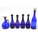 Four Georgian Bristol Blue decanters, brandy, hollands and rum, each with dummy stoppers, height