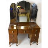 An Art Deco burr walnut veneered mirrored back dressing table, the triptych mirror back above an