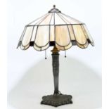 A reproduction Art Nouveau style table lamp with leaded glazed shade above the cast metal base,