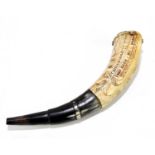 A reproduction powder horn with carved decoration of verses and figures and buildings, length 29cm.