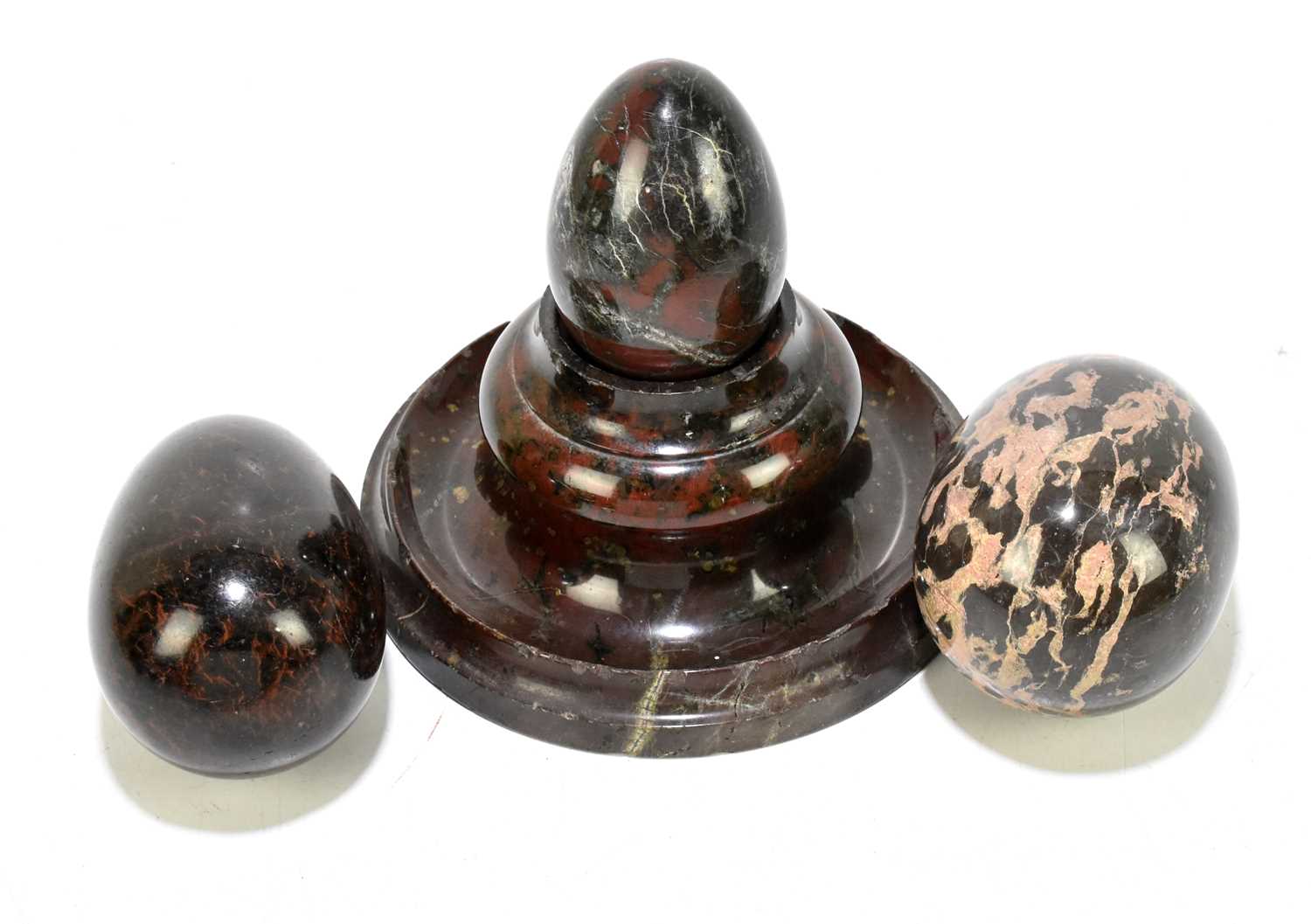 Three Cornish serpentine eggs, together with a serpentine match holder (4).