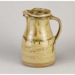 † RICHARD BATTERHAM (1936-2021); a stoneware jug covered in green ash glaze, height 22cm.Condition
