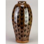 † PHIL ROGERS (1951-2020); a tall faceted stoneware vase covered in kaki glaze with wax resist