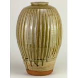 † PHIL ROGERS (1951-2020); a tall fluted stoneware bottle covered in running green ash glaze,