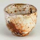 CHARLES BOUND (born 1939); a wood fired stoneware cup covered in shino and ash glaze with iron