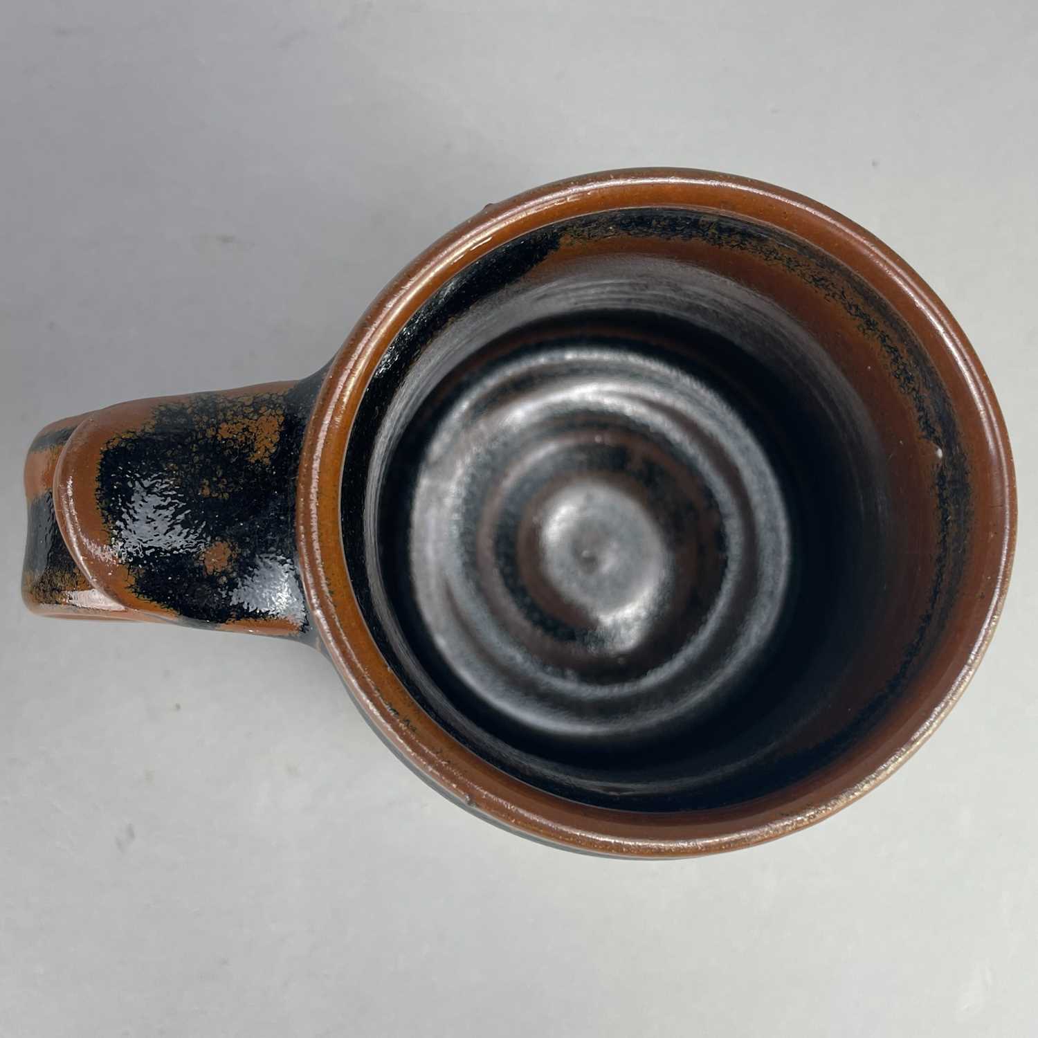 Leach Pottery; a stoneware mug covered in tenmoku breaking to kaki glaze, impressed pottery mark, - Image 4 of 6