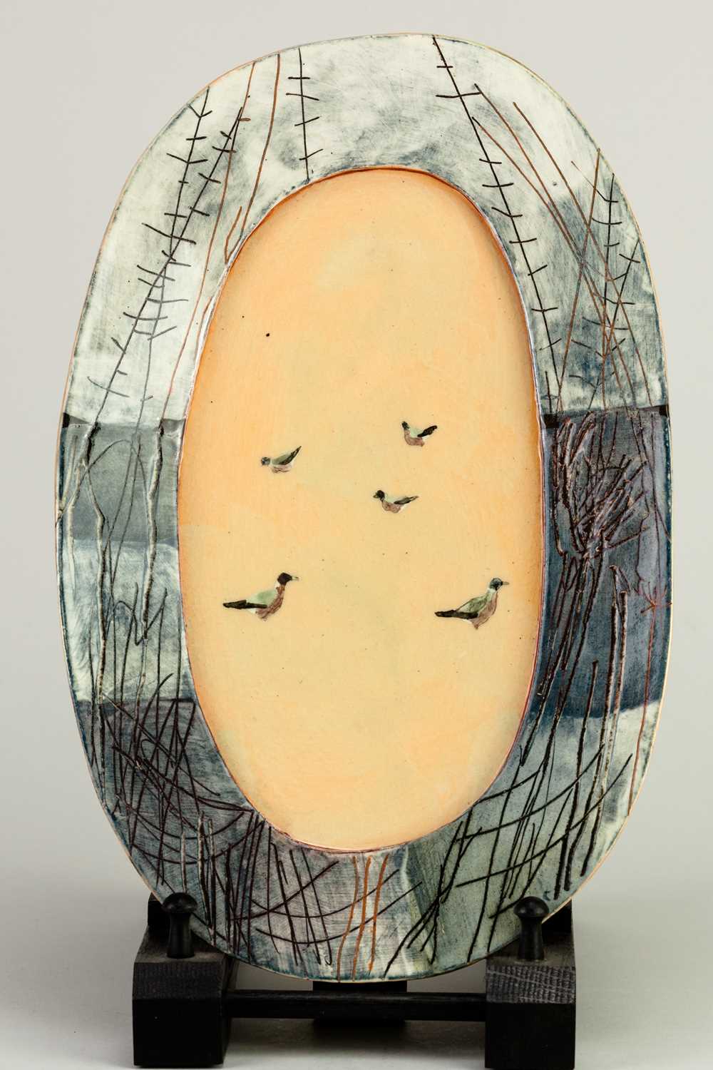 † ANNA LAMBERT (born 1957); an oval earthenware platter/wall hanging decorated with trees and birds,