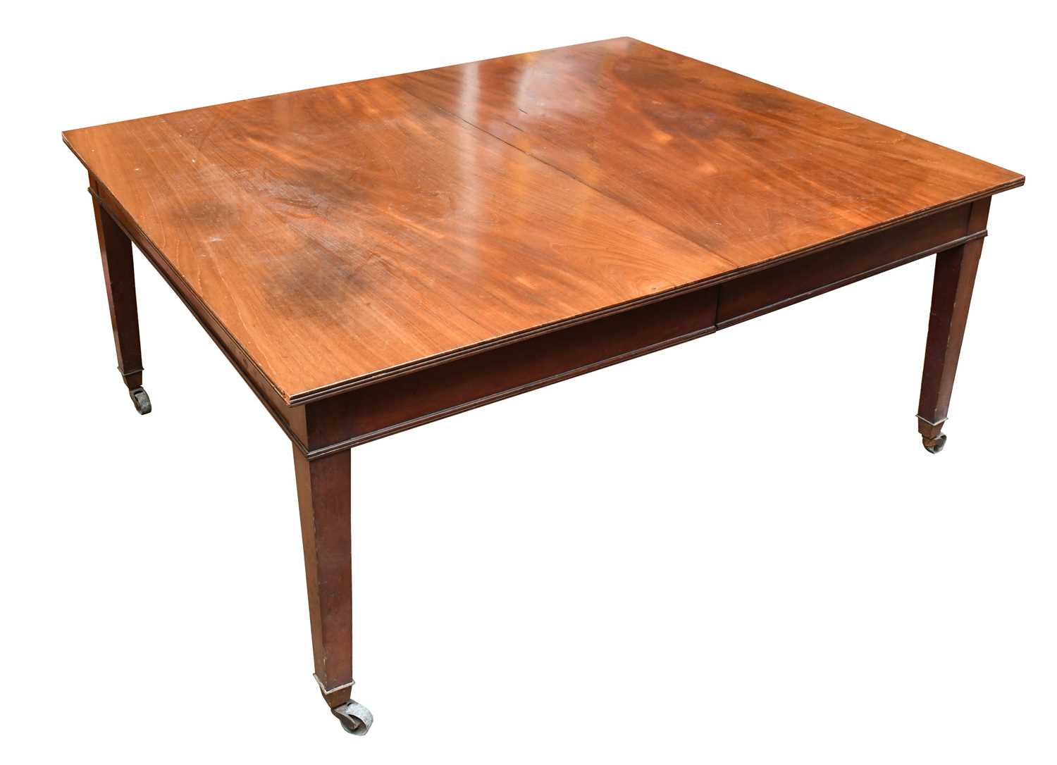 An Edwardian mahogany extending dining table of George III design, with two spare leaves, on tapered