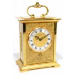 IMHOF; a contemporary gilt metal mantel clock with shaped handle and applied scrolling detail with