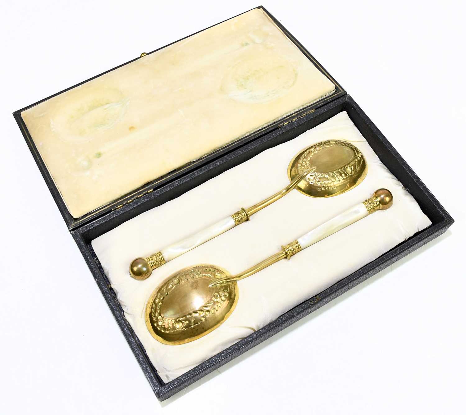 A pair of late Victorian gilt plated serving spoons, with mother of pearl handles, length 23.5cm,