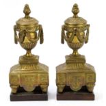 A pair of decorative brass side ornaments, modelled as urns with fruit finials and swags,