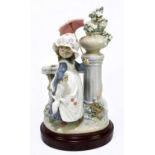 LLADRO; a figure of a girl with a parasol bedside a floral urn, height 27cm, on associated base.