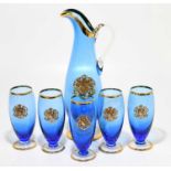 A set of five blue drinking glasses each with coat of arms, together with matching jug, height of