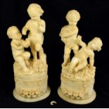 An unusual pair of early 20th century composite marble cherub groups, each modelled with two cherubs