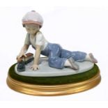 LLADRO; a figure of a boy with a train 'All Aboard' no 7619, height 12.5cm, with an oval base.
