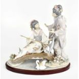 LLADRO; a large figure group representing two Geisha girls, one seated on a bridge beside a swan