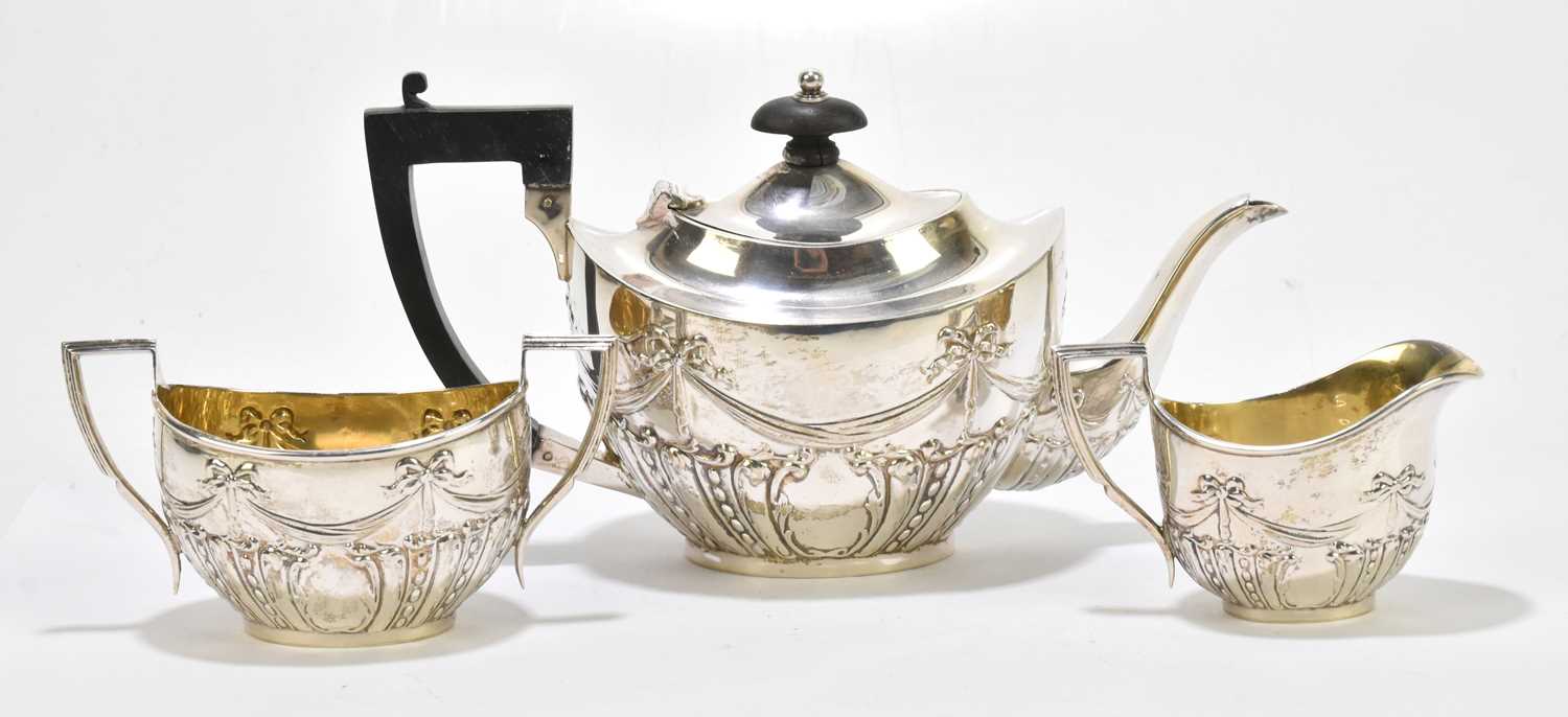 WILLIAM J HOLMES; an Edward VII hallmarked silver three piece bachelor's tea service, repoussé