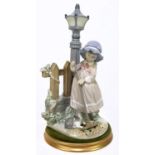 LLADRO; a figure of a girl sweeping beside a lamp post, height 33cm, with a circular base.