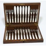 An early 20th century oak cased canteen of silver plated fish knives and forks with mother of