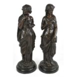 A pair of late 19th century French bronze figures of classical maidens, on circular bases, height