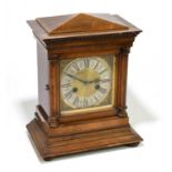 A late Victorian walnut eight day mantel clock, with silvered Roman numeral chapter ring and