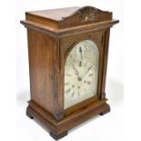 An Edwardian oak cased mantel clock, the silvered dial with Roman numerals and chime / silent
