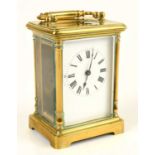 An early 20th century French brass cased carriage clock, the enamel dial set with Roman numerals,