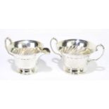 WALKER & HALL; a George V hallmarked silver twin handled sugar bowl and matching cream jug with