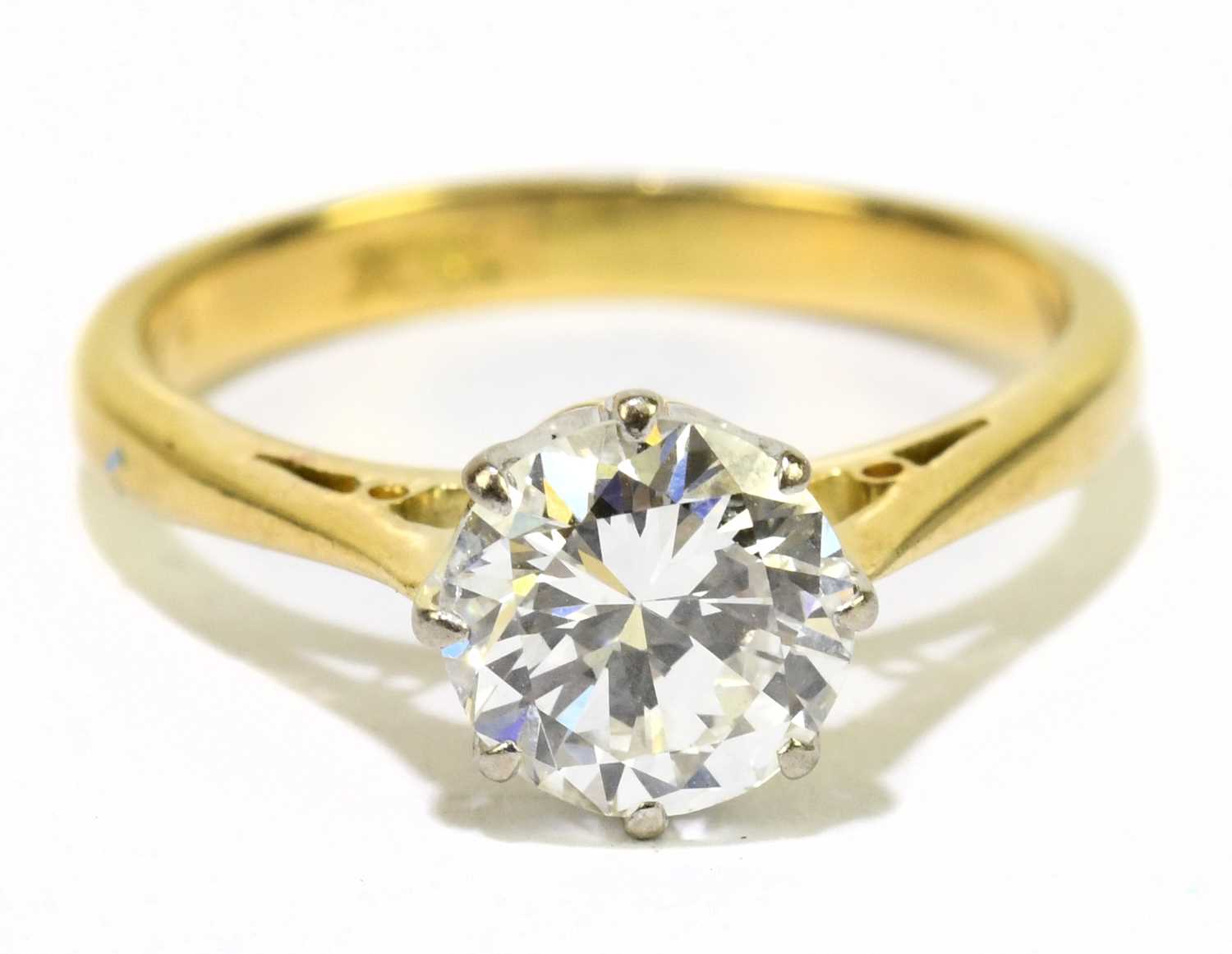 An 18ct yellow gold and diamond solitaire ring, the round brilliant cut eight claw set stone approx.