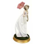 LLADRO; a ceramic figure of a girl with parasol, 7636, height 27cm, on circular stand.Condition