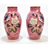 A pair of late 19th century French opaque pink glass vases with painted floral detailing, height