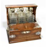 A late Victorian oak three bottle tantalus/games compendium, with silver plated mount, width 35cm,