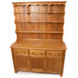 ERCOL; a light elm dresser with plate rack back, with three fixed shelves above an arrangement of