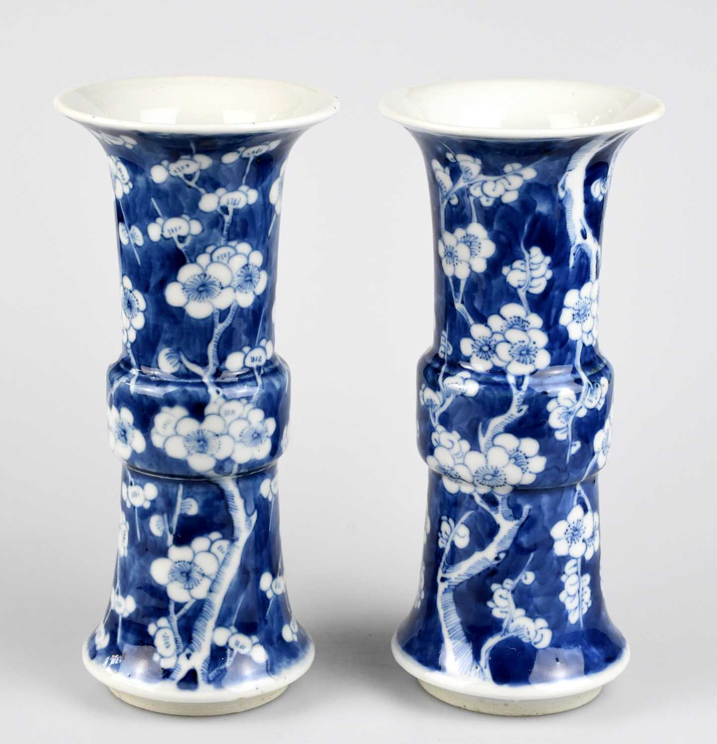 A pair of late 19th century Chinese blue and white porcelain Gu vases painted with prunus flowers on