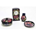 MOORCROFT; four 'Anemone' pattern items, comprising a timepiece, bowl and cover, small vase, and pin