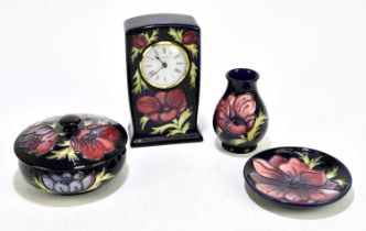 MOORCROFT; four 'Anemone' pattern items, comprising a timepiece, bowl and cover, small vase, and pin