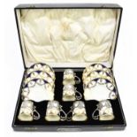 AYNSLEY; a cased twelve piece coffee service with hallmarked silver cup holders, London 1932, the